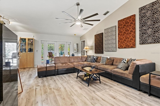 living room featuring ceiling fan, french doors, vaulted ceiling, and light wood-type flooring