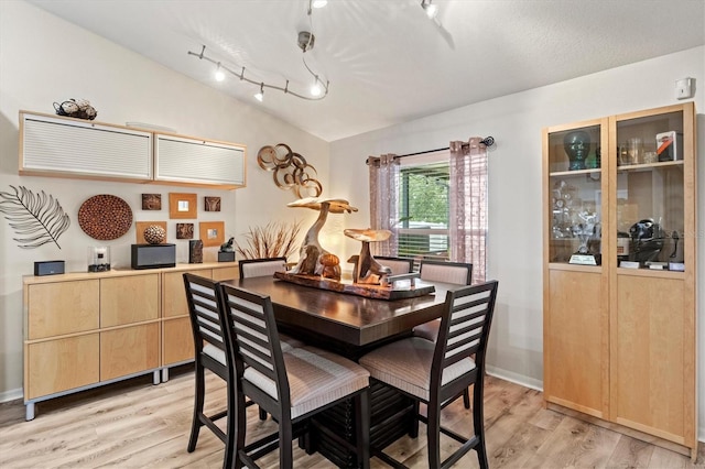 dining space featuring light hardwood / wood-style floors and vaulted ceiling