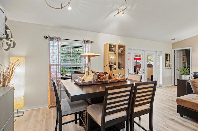 dining room with a healthy amount of sunlight, french doors, and light hardwood / wood-style flooring