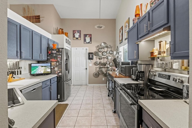 kitchen featuring stainless steel appliances, sink, blue cabinetry, pendant lighting, and light tile patterned floors