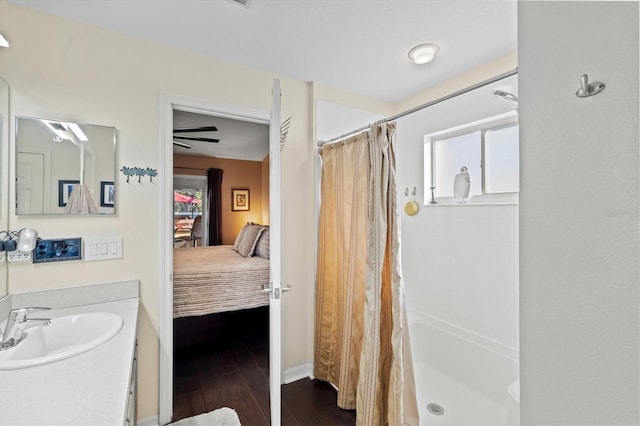 bathroom with wood-type flooring, curtained shower, and sink