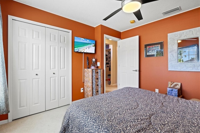 carpeted bedroom featuring ceiling fan and a closet