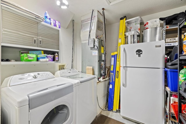 laundry area featuring cabinets, a textured ceiling, and independent washer and dryer