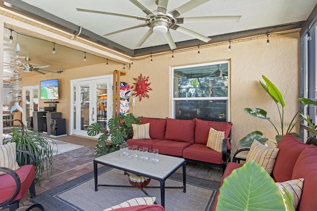 sunroom / solarium featuring ceiling fan, a wealth of natural light, and french doors