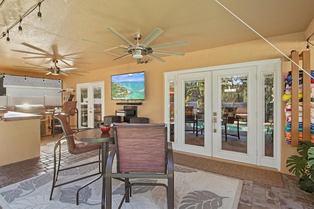 sunroom featuring ceiling fan, french doors, and rail lighting