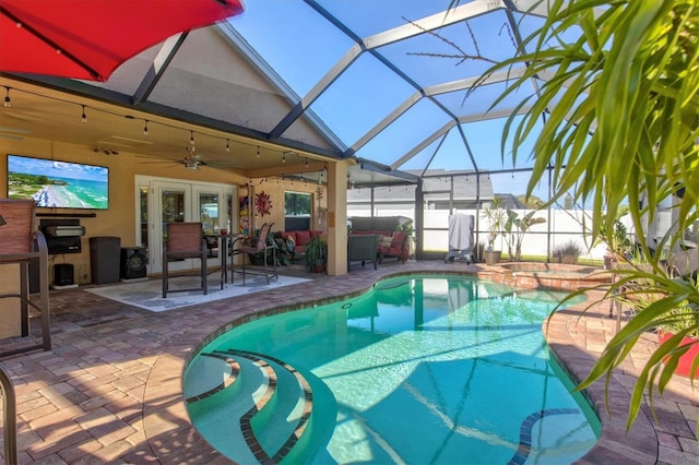 view of pool with glass enclosure, french doors, ceiling fan, an in ground hot tub, and a patio area