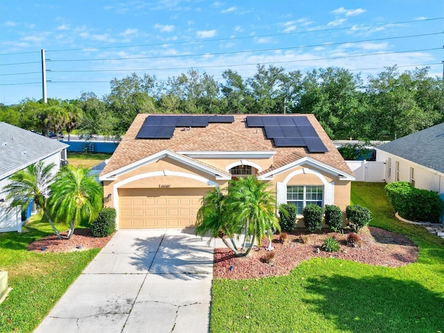 view of front of property with solar panels, a garage, and a front lawn