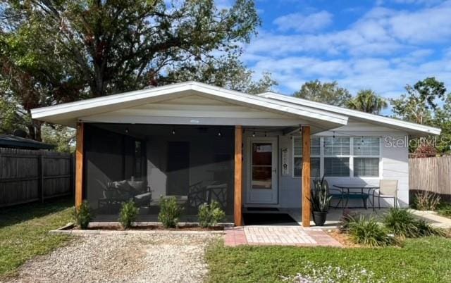 view of front of property featuring a front lawn and a sunroom