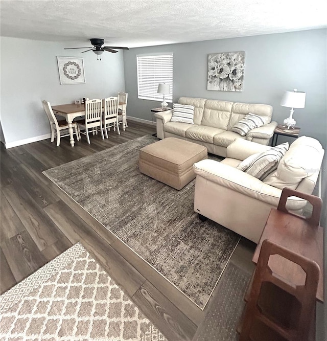 living room featuring a textured ceiling, ceiling fan, and dark hardwood / wood-style flooring