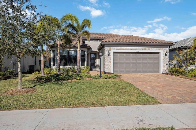 mediterranean / spanish-style house with a garage and a front lawn