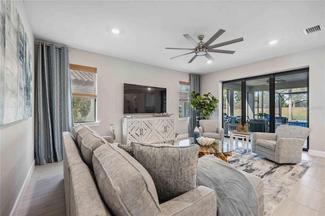 living room with ceiling fan and light hardwood / wood-style flooring