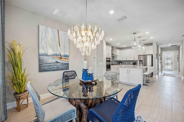 dining area with a notable chandelier, light tile patterned flooring, and sink