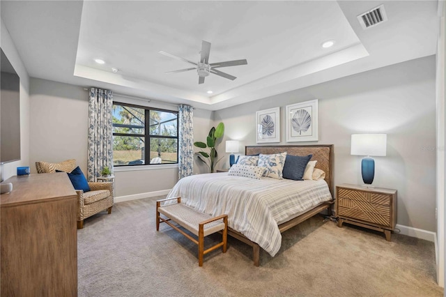 bedroom featuring a tray ceiling, ceiling fan, and light colored carpet