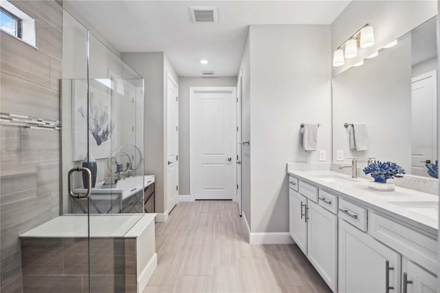 bathroom with vanity and a shower with door