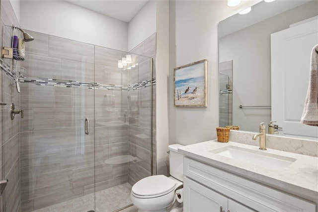 bathroom with walk in shower, vanity, and toilet