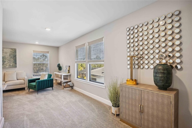 sitting room featuring light carpet and plenty of natural light