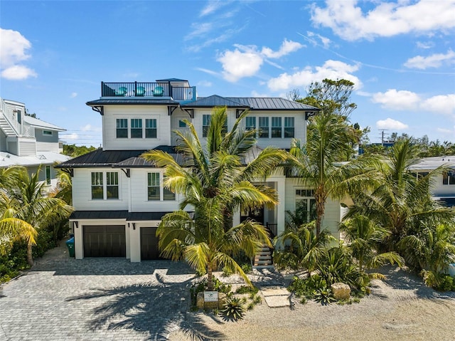 coastal inspired home with a balcony and a garage