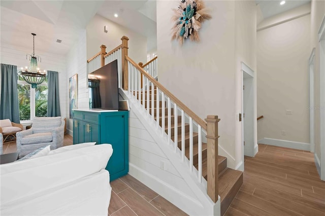 staircase featuring a high ceiling and a notable chandelier