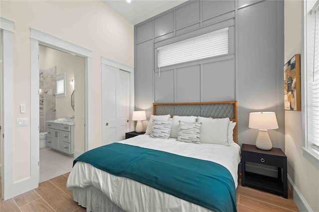 bedroom featuring a closet, ensuite bath, and multiple windows