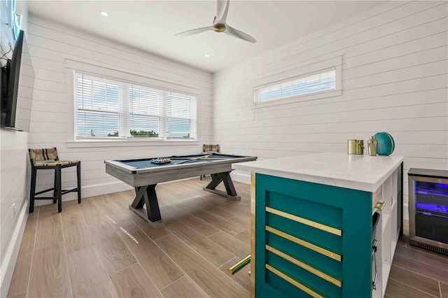 game room featuring ceiling fan, pool table, hardwood / wood-style flooring, wine cooler, and wood walls