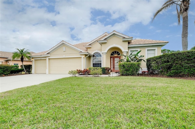 mediterranean / spanish house with a garage, french doors, and a front lawn