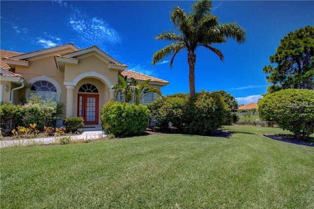 view of front facade featuring a front yard and french doors