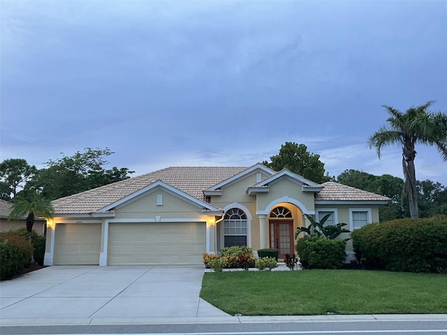 view of front of home with a front yard and a garage