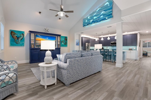 living room featuring light hardwood / wood-style floors, high vaulted ceiling, and ceiling fan