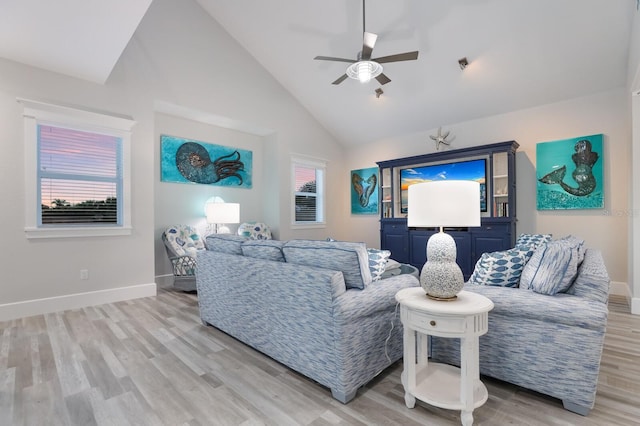 living room with ceiling fan, light hardwood / wood-style flooring, high vaulted ceiling, and a healthy amount of sunlight