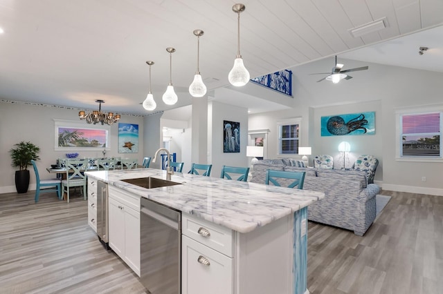 kitchen with white cabinetry, dishwasher, sink, hanging light fixtures, and an island with sink