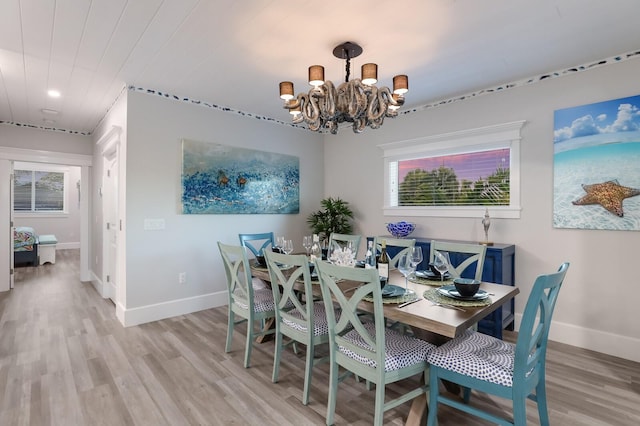 dining space with light hardwood / wood-style floors and a chandelier