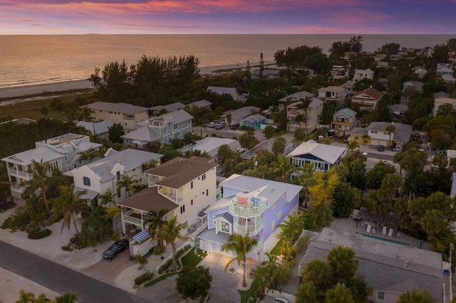 aerial view at dusk featuring a water view