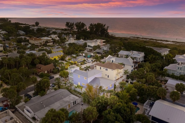 aerial view at dusk featuring a water view