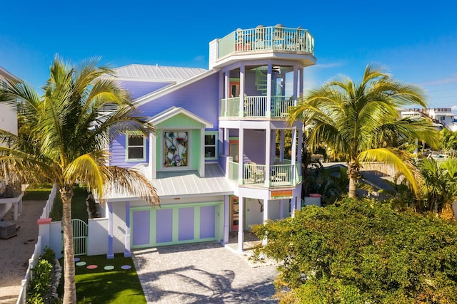 coastal inspired home featuring a balcony and a garage