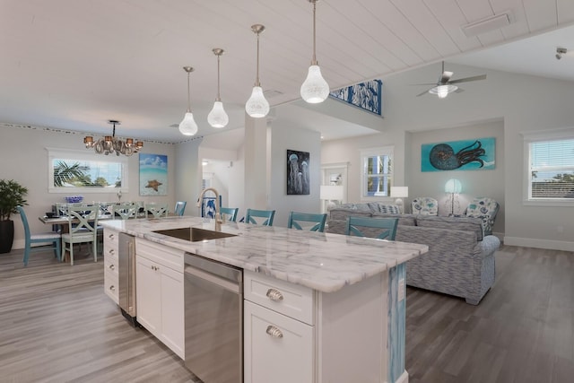 kitchen with stainless steel dishwasher, sink, white cabinetry, hanging light fixtures, and an island with sink