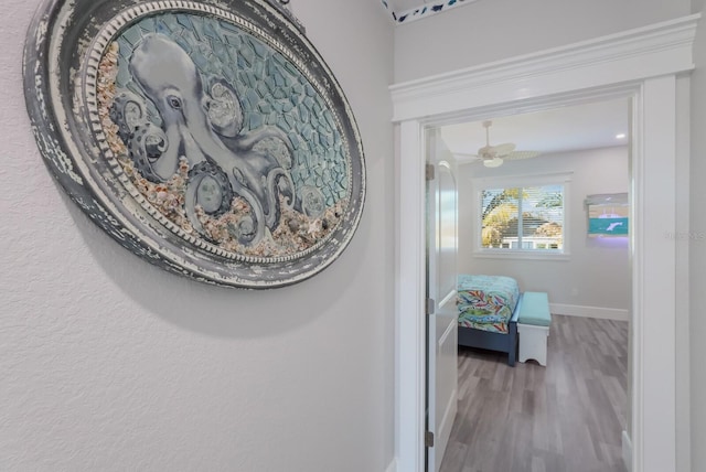 room details with wood-type flooring, ceiling fan, and crown molding