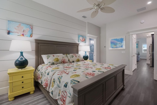 bedroom featuring ceiling fan, stainless steel fridge, and dark hardwood / wood-style floors