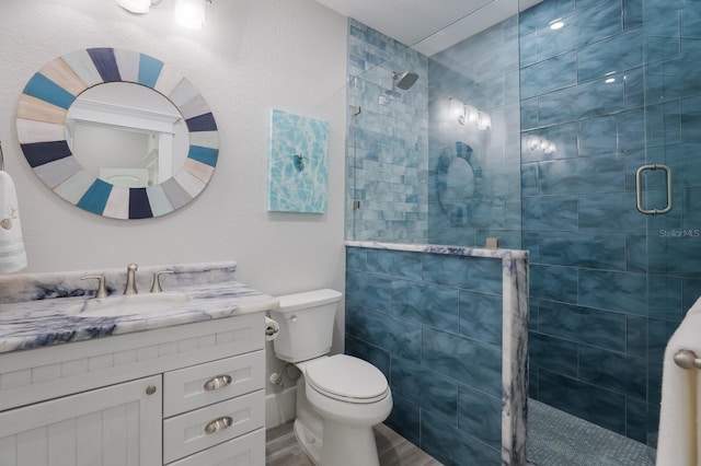 bathroom with vanity, an enclosed shower, and toilet