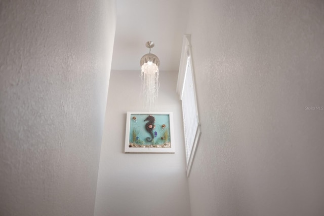 stairs with an inviting chandelier