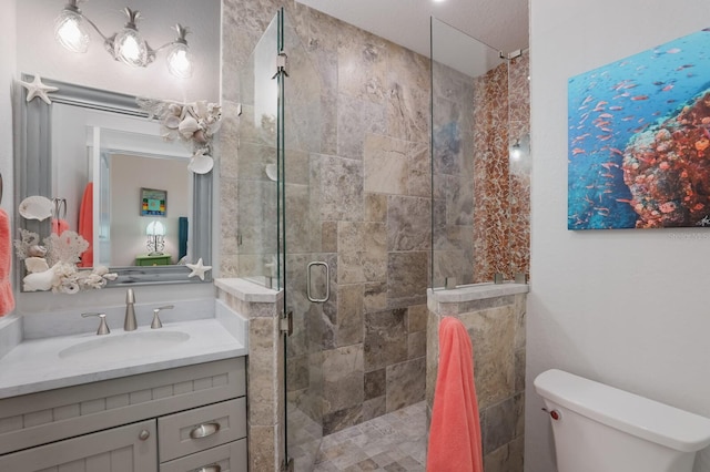 bathroom featuring vanity, toilet, and a shower with shower door