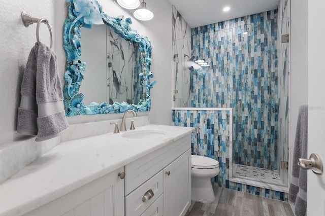 bathroom with walk in shower, toilet, vanity, and hardwood / wood-style flooring