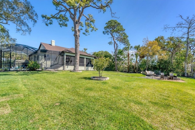 view of yard with glass enclosure and a patio