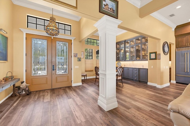 entrance foyer with ornate columns, french doors, a chandelier, and dark wood-type flooring