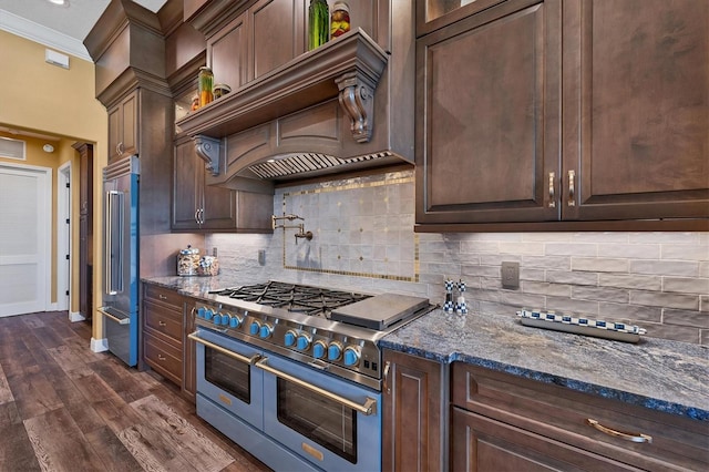 kitchen featuring backsplash, dark stone counters, custom range hood, and high end appliances