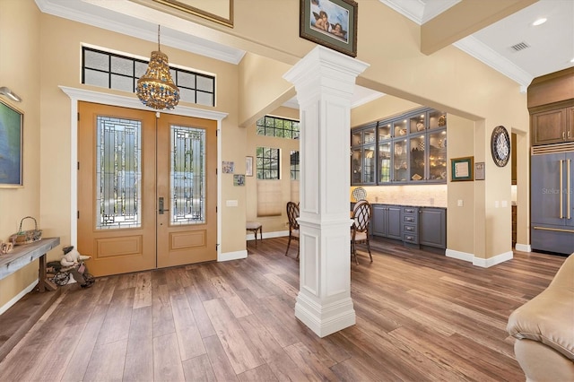 entryway with ornate columns, wood finished floors, and visible vents