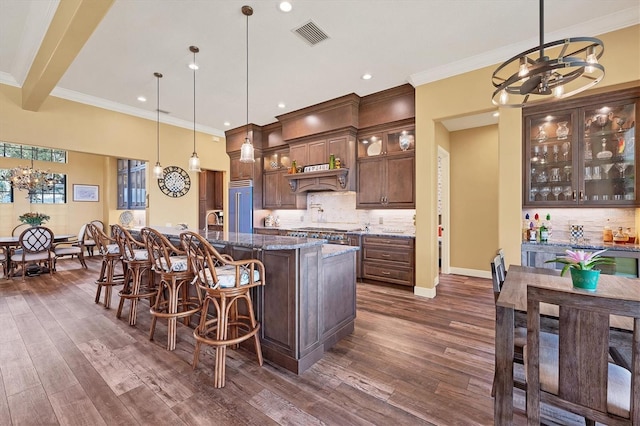 kitchen with visible vents, high end refrigerator, decorative backsplash, and a notable chandelier
