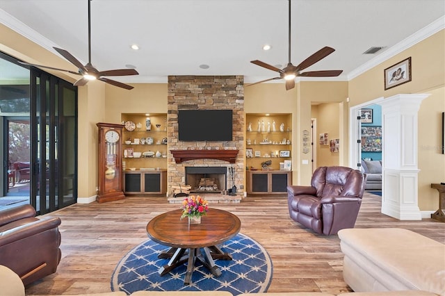 living area featuring crown molding, ceiling fan, wood finished floors, and visible vents