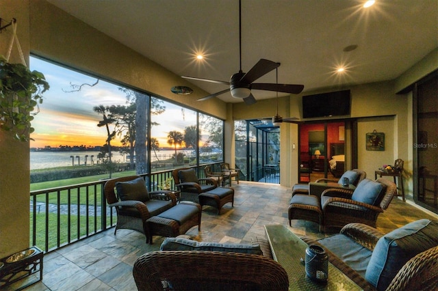sunroom / solarium featuring recessed lighting, a ceiling fan, a water view, and outdoor lounge area