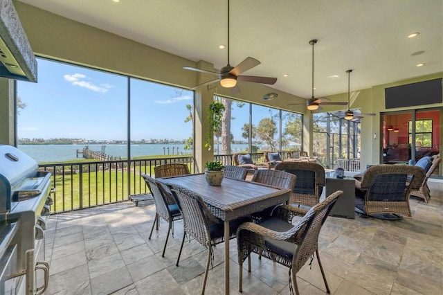 sunroom / solarium with a ceiling fan, outdoor dining space, and a water view