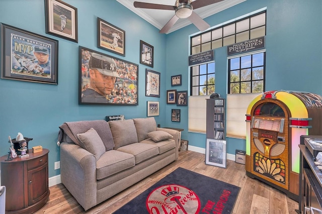 interior space featuring crown molding, a ceiling fan, baseboards, and wood finished floors
